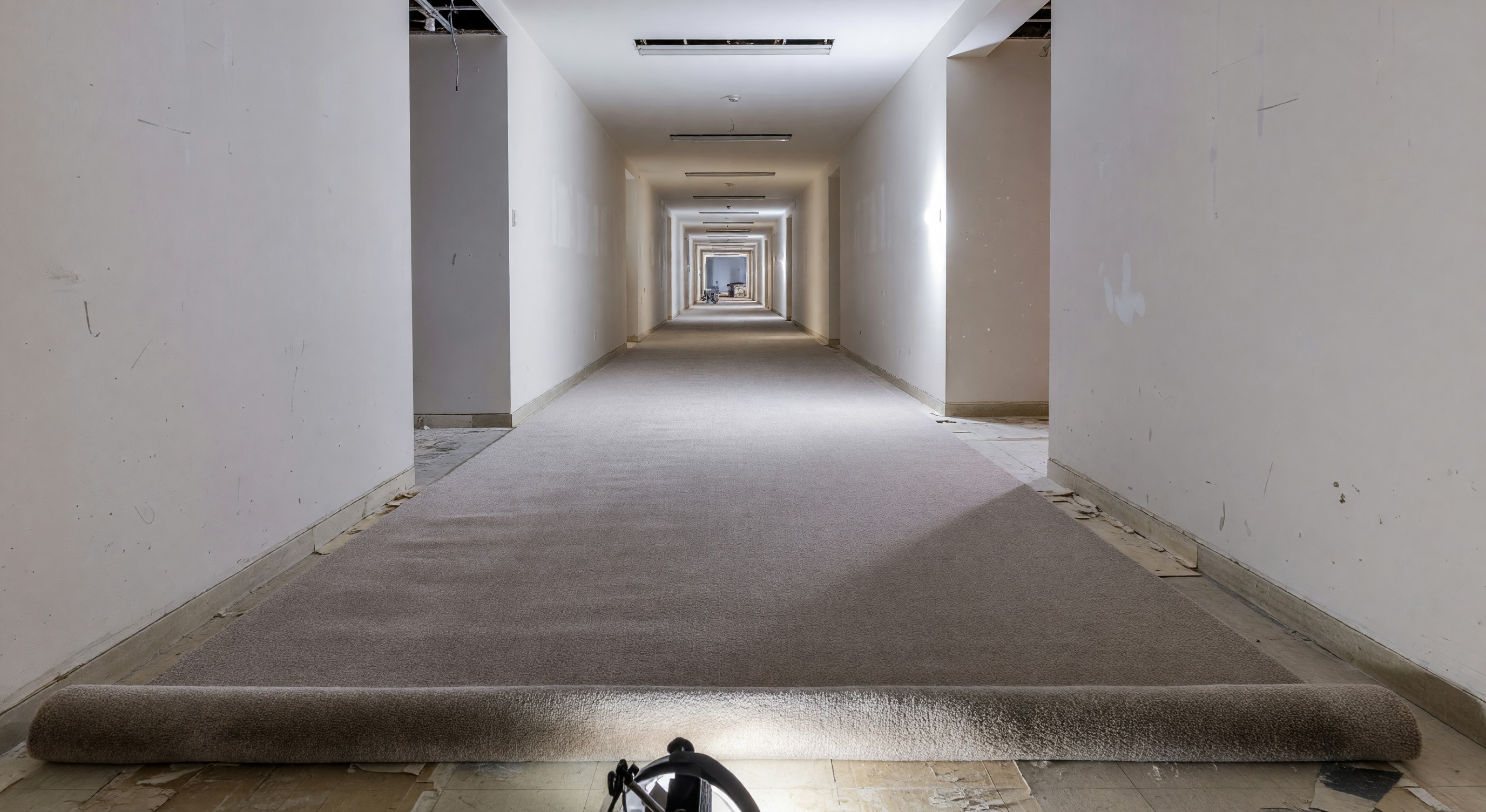 Hotel corridor with fresh carpet installation during renovation